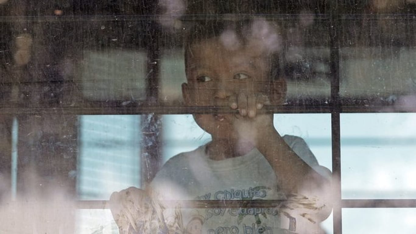 Ein Einwandererkind hinter der vergitterten Scheibe eines Busses der US-Border Patrol.