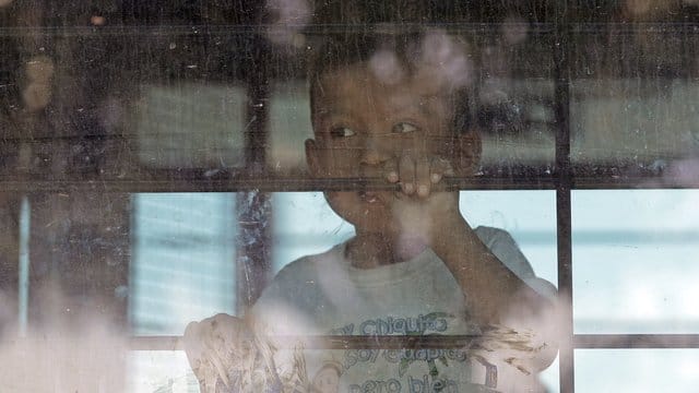 Ein Einwandererkind hinter der vergitterten Scheibe eines Busses der US-Border Patrol. Ein Einwandererkind hinter der vergitterten Scheibe eines Busses der US-Border Patrol.
