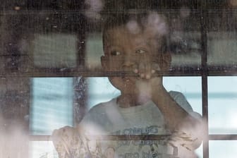 Ein Einwandererkind hinter der vergitterten Scheibe eines Busses der US-Border Patrol.