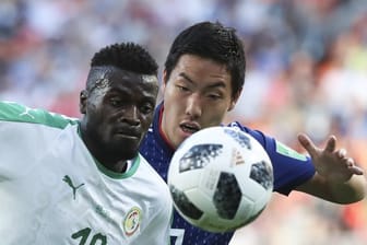 Senegals M'Baye Niang aus Senegal (l) kämpft mit Gen Shoji aus Japan um den Ball.