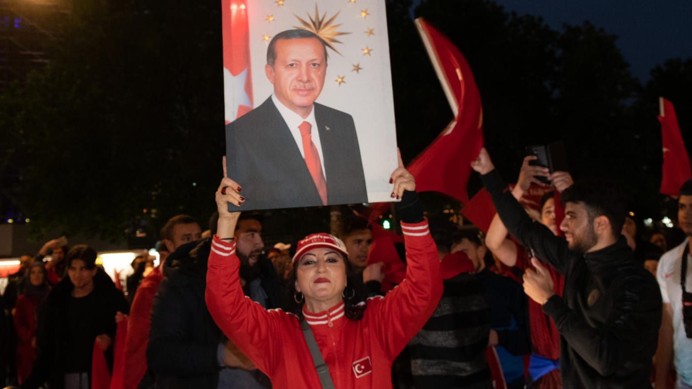 Eine Erdogan-Anhängerin auf dem Kurfürstendamm in Berlin mit Erdogan-Porträt: Grünen-Politiker Özdemir kritisiert das Wahlverhalten der Deutsch-Türken.