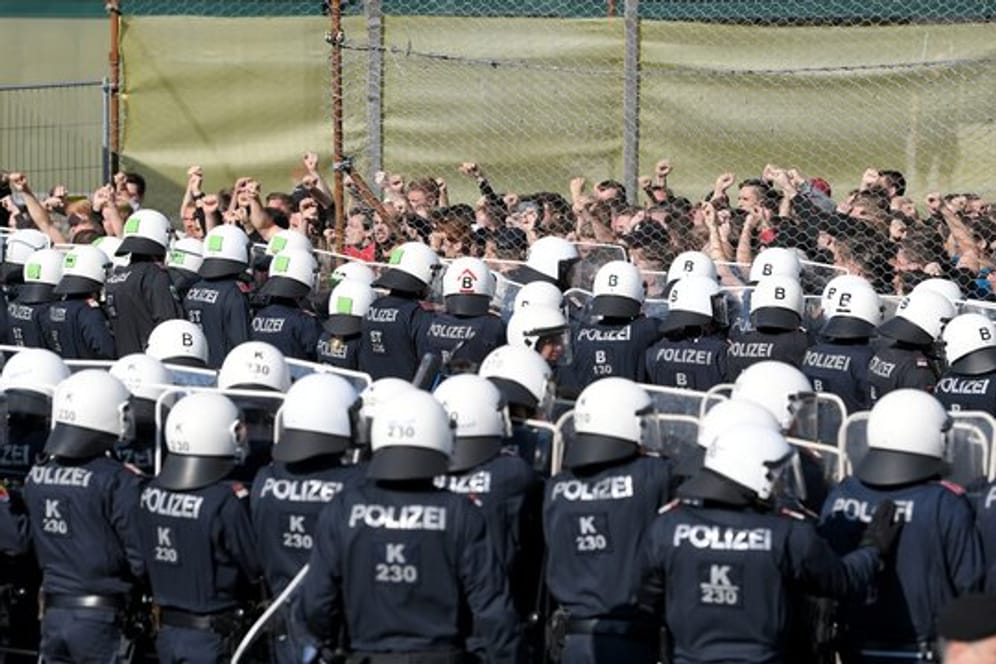Österreichische Polizisten und Flüchtlingsdarsteller stehen im Rahmen der Grenzschutzübung "ProBorders" an der Grenze zu Slowenien im Ort Spielfeld.