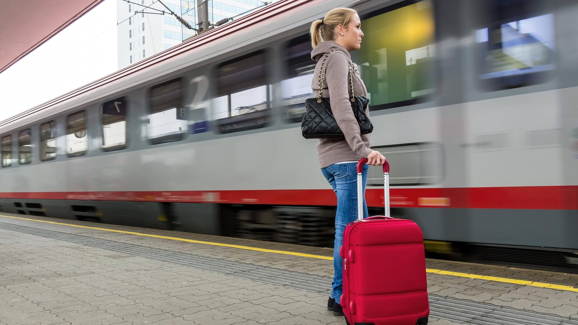 Eine junge Frau wartet auf einen Zug in einem Bahnhof