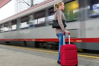 Eine junge Frau wartet auf einen Zug in einem Bahnhof