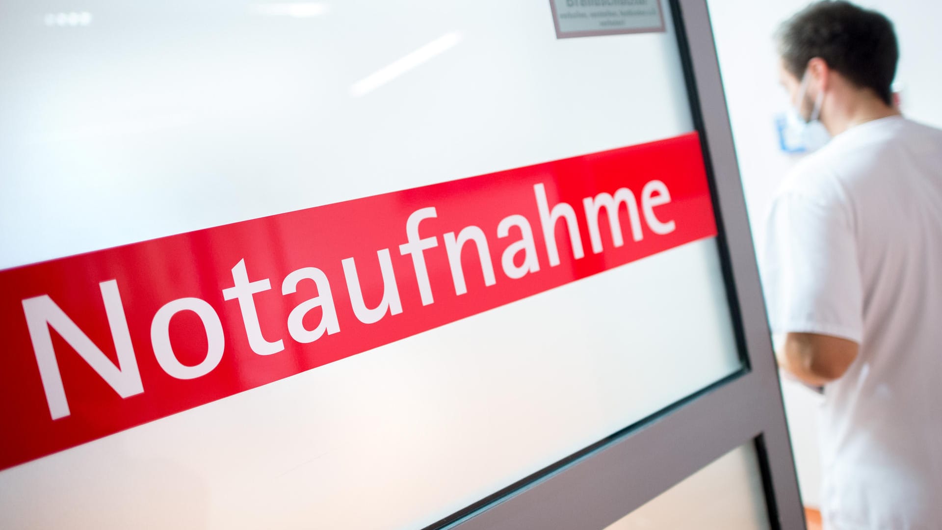 Ein Krankenpfleger geht durch eine Glastür mit der Aufschrift "Notaufnahme".