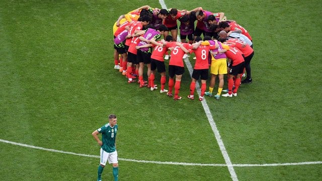 Die Mannschaft aus Südkorea bildet nach dem Spiel einen Kreis, während Toni Kroos den Platz verlässt.