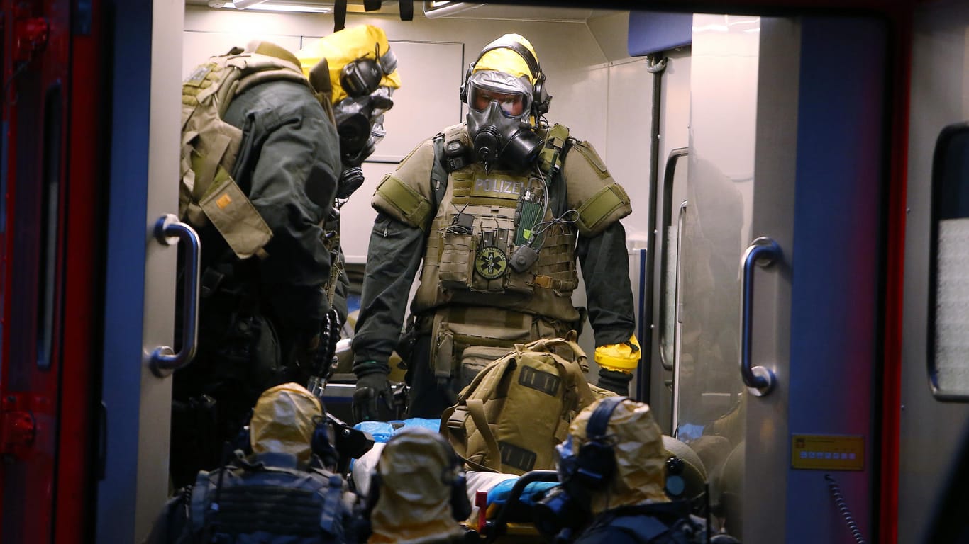 Mitte Juni in Köln: SEK-Beamte mit Atemschutzmasken und Schutzanzügen stehen vor einem Kölner Wohnkomplex, in dem der Tunesier Sief Allah H. einen Terroranschlag vorbereitet haben soll.