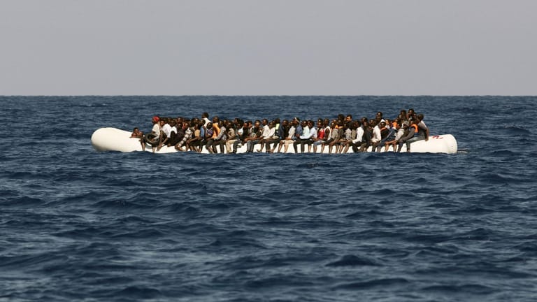 Überfülltes Schlauchboot vor der libyschen Küste: Das Schicksal der etwa 100 am Freitag gekenterten Menschen ist bislang unklar (Archiv).