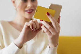 Eine Frau nutzt Online-Banking: Auch Zuhause sollte man auf Sicherheit bei Geldgeschäften am Smartphone achten.