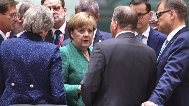 Die Bundeskanzlerin umringt von anderen Staats- und Regierungschefs während des EU-Gipfels. Die Bundeskanzlerin umringt von anderen Staats- und Regierungschefs während des EU-Gipfels.