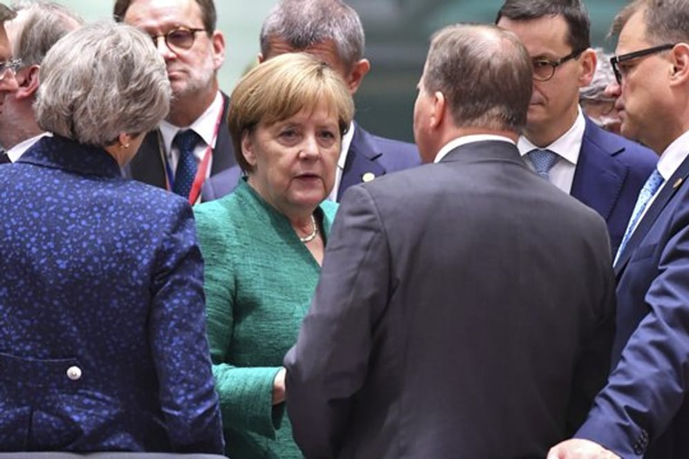 Die Bundeskanzlerin umringt von anderen Staats- und Regierungschefs während des EU-Gipfels.