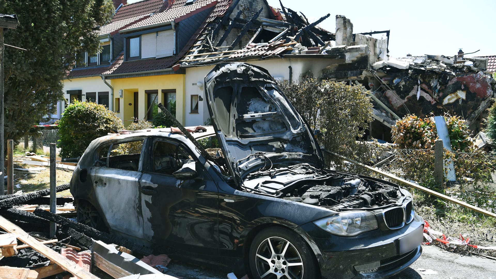 Ein abgebranntes Auto steht in der Einfahrt eines zerstörten Wohnhauses: Drei Menschen starben bei einer Explosion in Bremen. Ein abgebranntes Auto steht in der Einfahrt eines zerstörten Wohnhauses: Drei Menschen starben bei einer Explosion in Bremen.