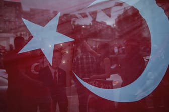 Anhänger des türkischen Präsidenten Erdogan nach der Wahl hinter einer Flagge: Die türkischen Behörden haben am Wochenende ein türkische Schule schließen lassen.