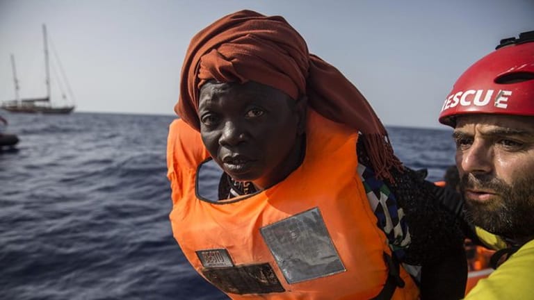 Eine Migrantin zusammen mit einem Freiwilligen der Hilfsorganisation Proactiva Open Arms in einem Schlauchboot vor der Küste Libyens.