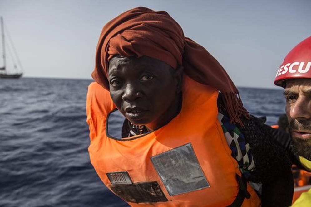 Eine Migrantin zusammen mit einem Freiwilligen der Hilfsorganisation Proactiva Open Arms in einem Schlauchboot vor der Küste Libyens.