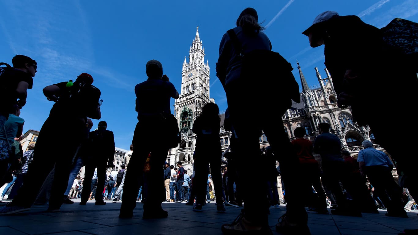 München: Touristen und Einheimische verfolgen das Glockenspiel auf dem Marienplatz.