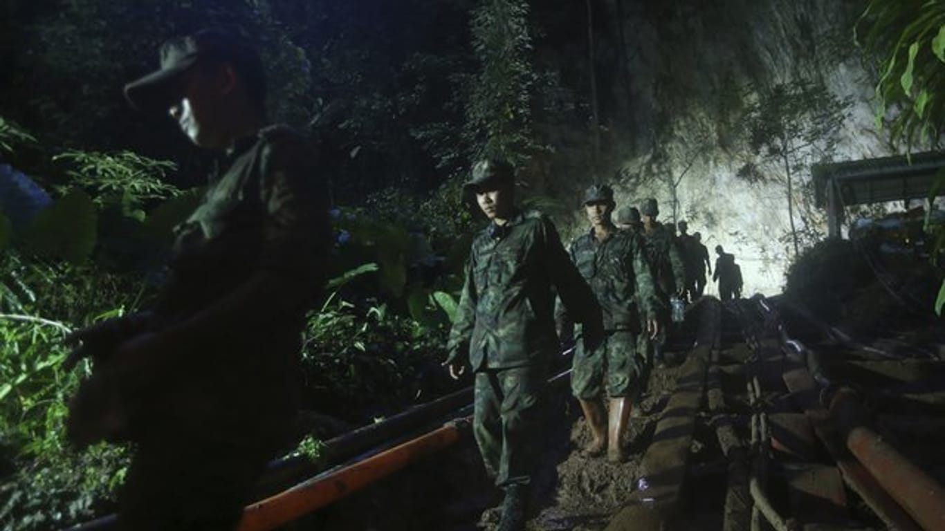 Mitglieder einer Suchmannschaft im Eingang des Höhlensystems, in dem zwölf Jungen einer Fußballmannschaft und ihr Trainer vermisst werden.