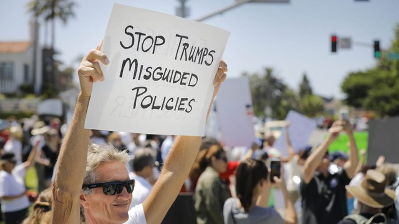 Menschen protestieren in Carlsbad, Kalifornien, mit Schildern gegen die US-Einwanderungspolitik.