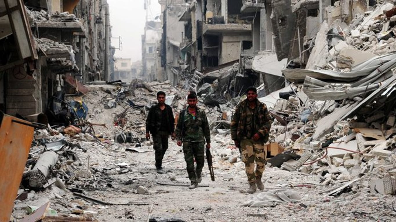 Syrische Soldaten in einem weitgehend zerstörten Vorort von Damaskus.