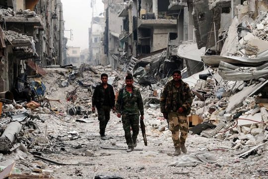 Syrische Soldaten in einem weitgehend zerstörten Vorort von Damaskus.