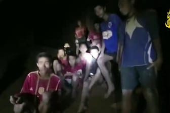 Ein Video-Standbild einer thailändischen Spezialeinheit zeigt die vermissten Jugendfußballer und ihren Trainer, nachdem sie in einer Höhle entdeckt wurden.