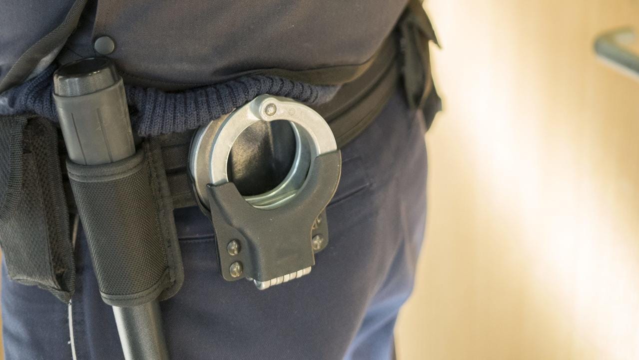 Polizist mit Handschellen: Die Wohnung der ehemaligen IS-Anhängerin wurde von Ermittlern durchsucht. (Symbolbild) Polizist mit Handschellen: Die Wohnung der ehemaligen IS-Anhängerin wurde von Ermittlern durchsucht. (Symbolbild)