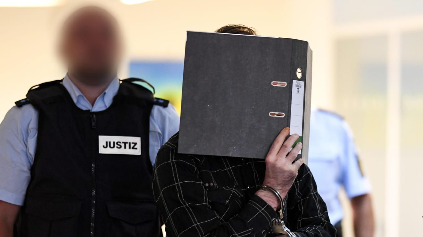 Der wegen Kindesmissbrauchs angeklagte Jürgen W. aus der Schweiz neben einem Justizbeamten: Dreimal soll der Schweizer das neunjährige Opfer missbraucht haben.