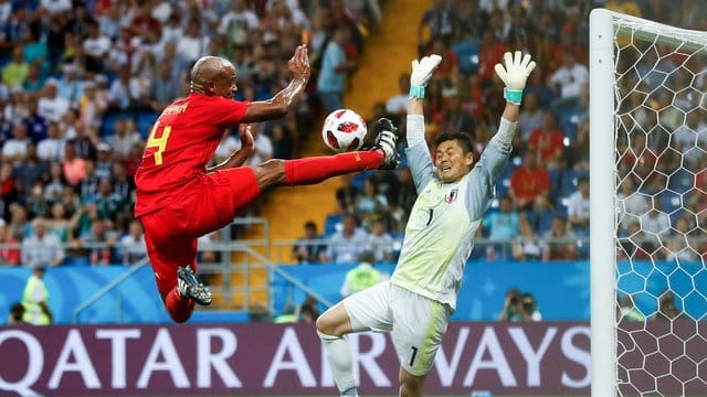 Akrobatik pur: Vincent Kompany aus Belgien (l) kämpft mit Torwart Eiji Kawashima aus Japan um den Ball.
