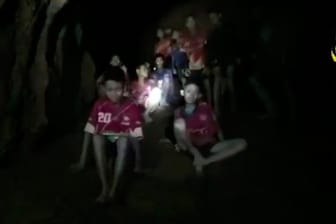 Bilder der Einsatzkräfte zeigen die Jugendlichen im Inneren der Höhle im Schein von Taschenlampen - erschöpft, aber überglücklich.