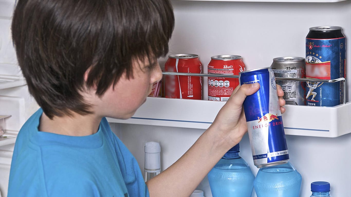Kind greift in Kühlschrank nach Energydrink