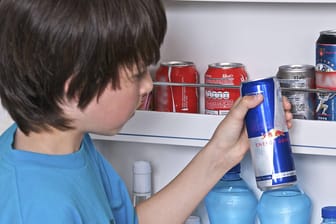 Kind greift in Kühlschrank nach Energydrink