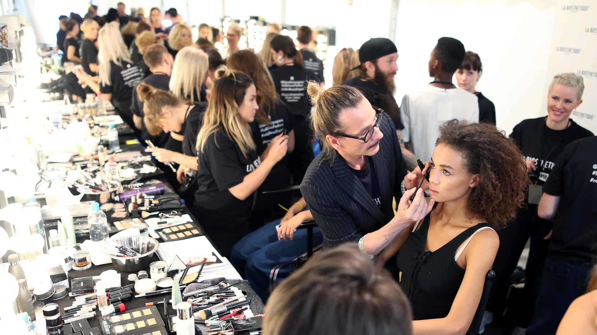 Mascara, Nagellack und Co.: Im Hintergrund arbeiten weitaus mehr als am Ende über den Catwalk gehen.