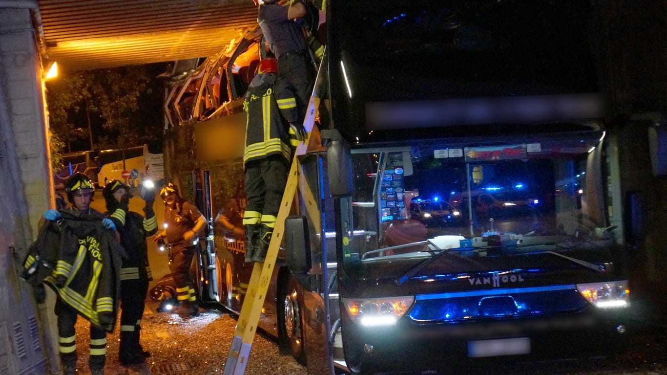 Der verunglückte Bus in Rimini: Feuerwehrleute arbeiten an dem Fahrzeug.