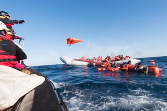 Mitarbeiter einer Hilfsinitiative werfen Flüchtlingen Rettungswesten zu: Neben Rettungsschiffen wurde auch der Start von Erkundungsflugzeugen auf Malta verboten.