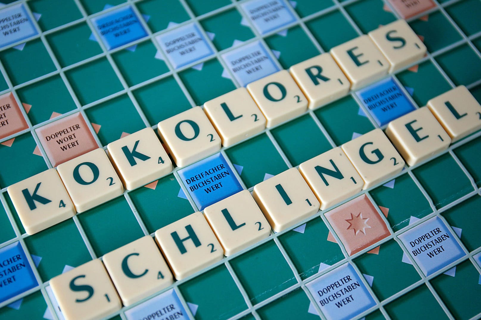 Die Wörter "Kokolores" (bedeutet: Unsinn) und "Schlingel" (bedeutet: Schlitzohr) liegen auf einem Scrabble-Brett: Viele ältere Worte geraten immer mehr in Vergessenheit.