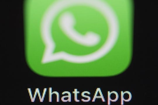 Das Logo der Messenger-App WhatsApp ist auf dem Bildschirm eines iPhones zu sehen.