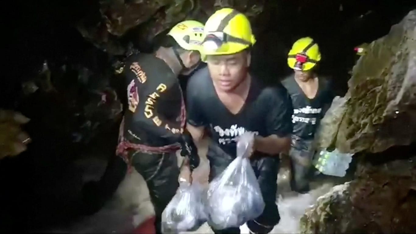 Helfer tragen Lebensmittel in die Höhle in Thailand, in der die zwölf Jungen und ihr Trainer eingeschlossen sind: Bei den Rettungsarbeiten ist ein Taucher ums Leben gekommen.