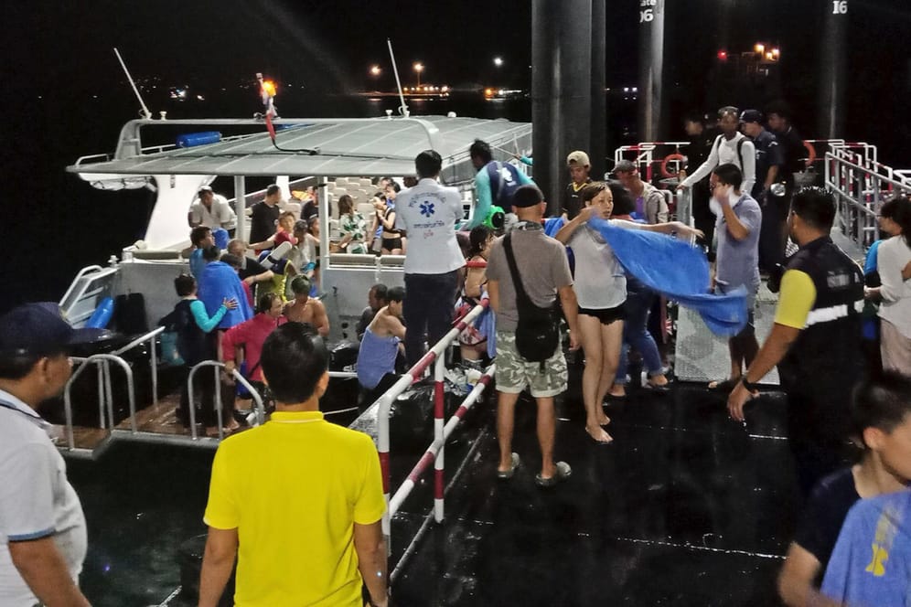 Ein Boot bringt gerettete Touristen an Land: Vor der Küste Thailands sind zwei Schiffe untergegangen.