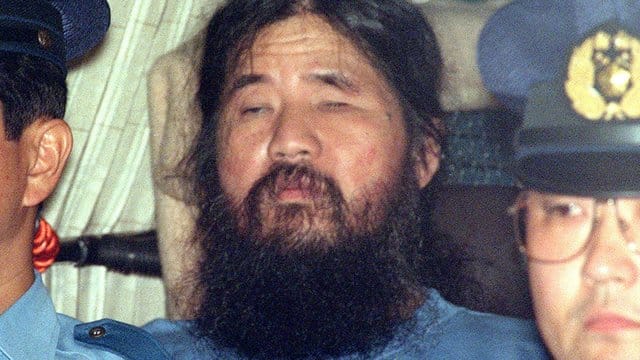 Shoko Asahara, Gründer der Endzeitsekte "Aum Shinrikyo", sitzt nach einem Verhör in einem Polizeifahrzeug.