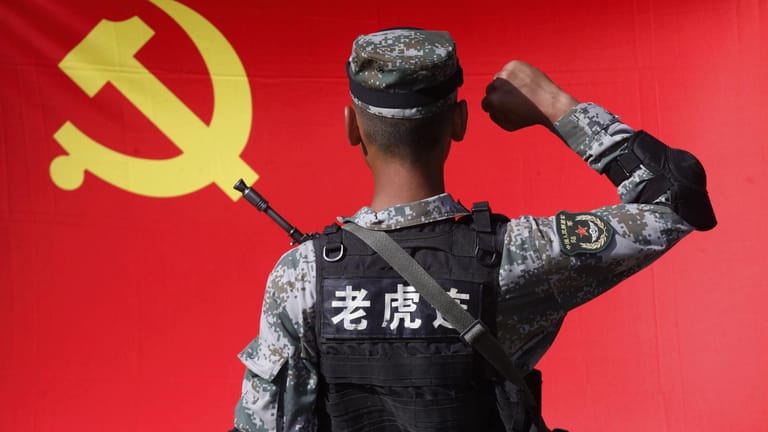 Ein chinesischer Soldat vor der Flagge: In Europa setzt China seinen Einfluss mit wirtschaftlichen Mitteln durch.