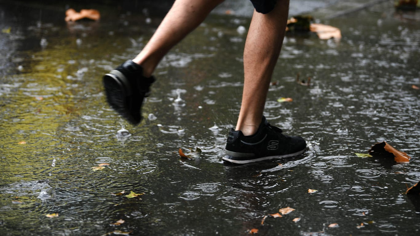 Ein Mann läuft bei Regen durch einen Dortmunder Park. Zu Beginn der neuen Woche macht der Sommer eine Pause.