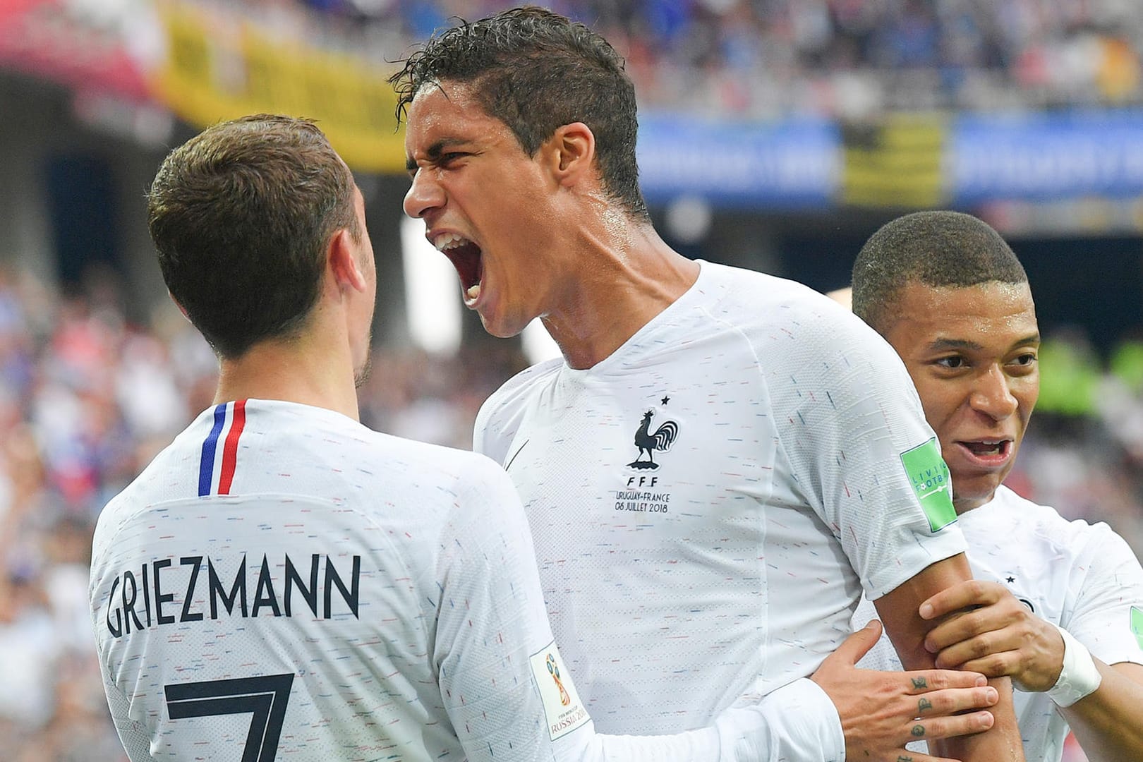 Antoine Griezmann (l.) und Kylian Mbappé (r.) feiern mit Raphael Varane dessen Treffer gegen Uruguay.