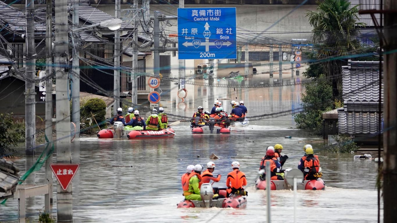 Retter in Schlauchbooten auf den überfluteten Straßen der Stadt Kurashiki city: Rund 3,6 Millionen Menschen in 18 Präfekturen sind aufgefordert, ihre Häuser zu verlassen.