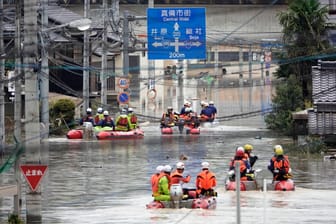 Retter in Schlauchbooten auf den überfluteten Straßen der Stadt Kurashiki city: Rund 3,6 Millionen Menschen in 18 Präfekturen sind aufgefordert, ihre Häuser zu verlassen.