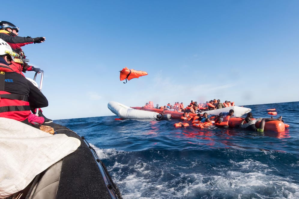 Mitarbeiter der Hilfsinitiative SOS Mediterranee werfen Flüchtlingen vor der libyschen Küste Rettungswesten zu.