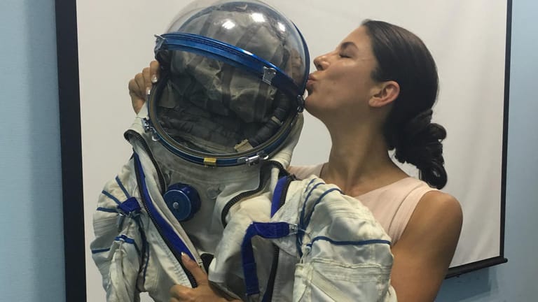Laura Winterling küsst den Helm eines Astronautenanzuges: Die 37-Jährige verfolgt den Traum, auch mal als Astronautin ins All fliegen zu können.