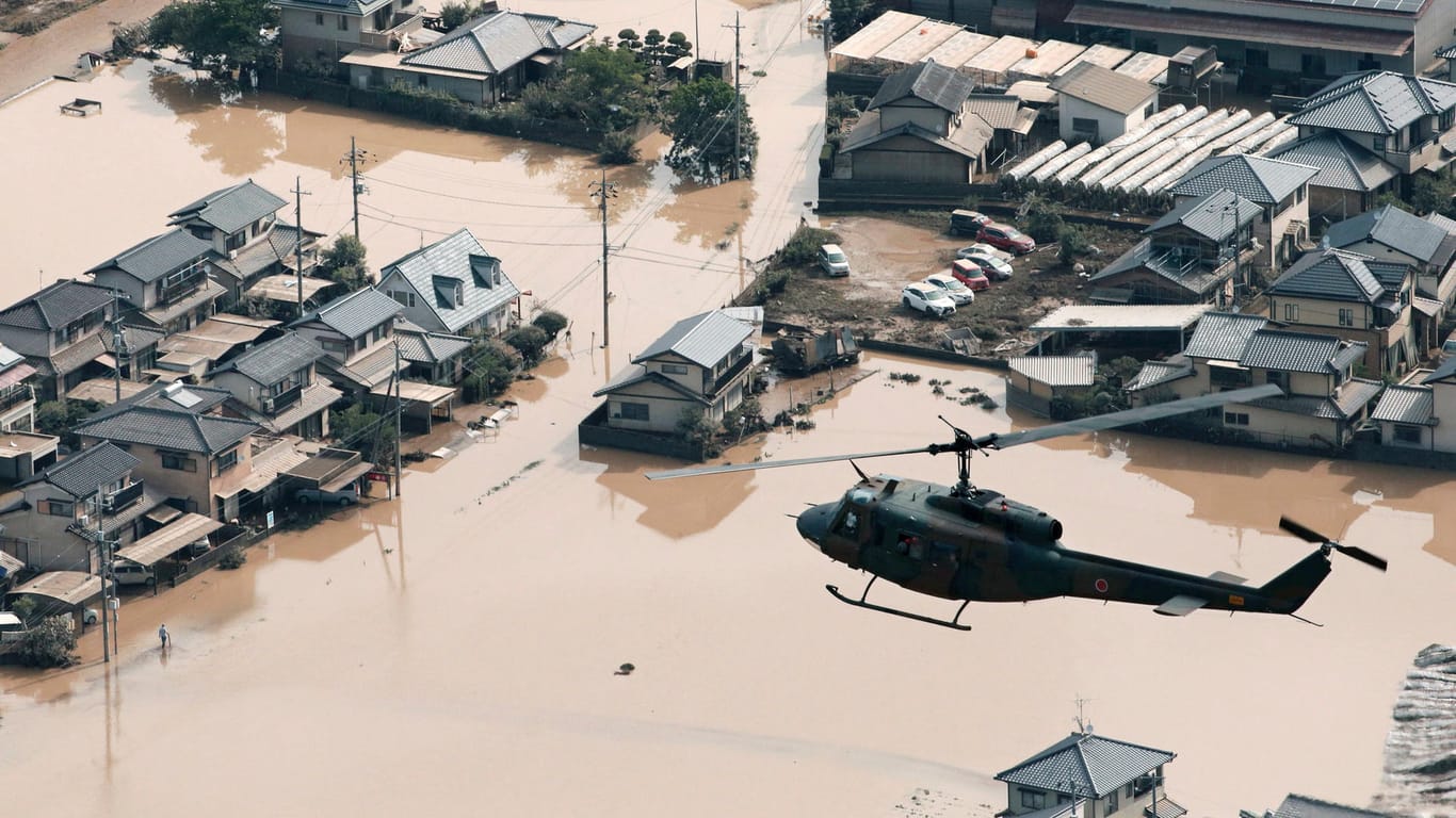 Ein Helikopter fliegt über ein überflutetes Wohngebiet in Kurashiki: Heftiger Regen hatte Straßen überflutet und Erdrutsche ausgelöst. Dutzende Menschen werden vermisst.