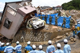 Einsatzkräfte suchen vermisste Personen in Kumano: Bei den Unwettern in Japan sind bislang mindestens 100 Menschen ums Leben gekommen.