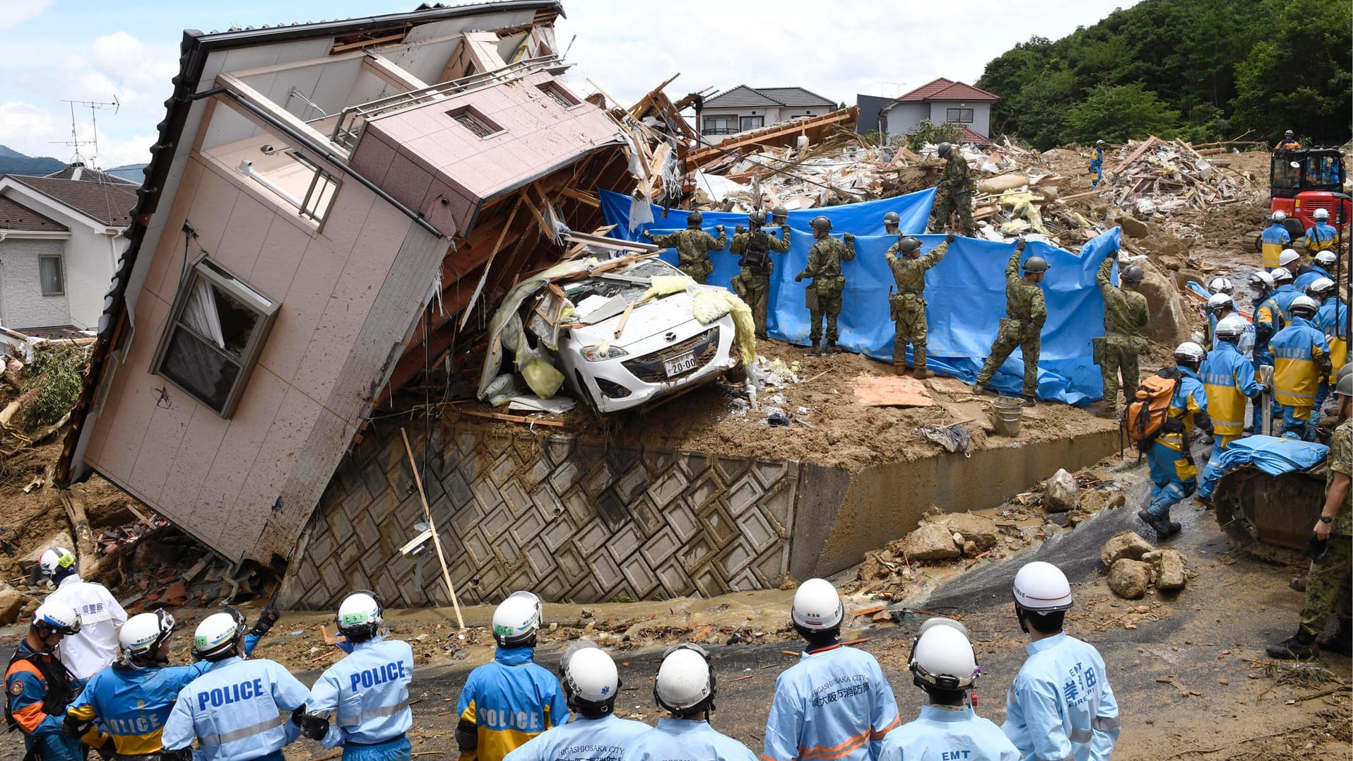 Einsatzkräfte suchen vermisste Personen in Kumano: Bei den Unwettern in Japan sind bislang mindestens 100 Menschen ums Leben gekommen. Einsatzkräfte suchen vermisste Personen in Kumano: Bei den Unwettern in Japan sind bislang mindestens 100 Menschen ums Leben gekommen.