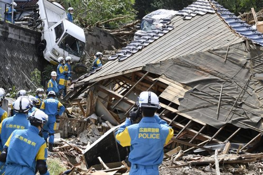 Nach einem Erdrutsch in Kumano suchen Einsatzkräfte der Feuerwehr nach Vermissten.
